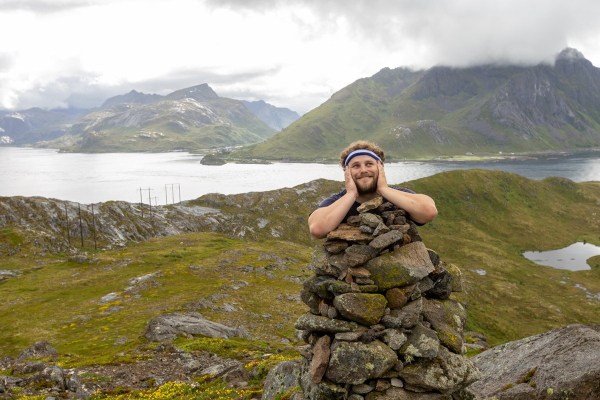 Man on a mountain summit, arms raised